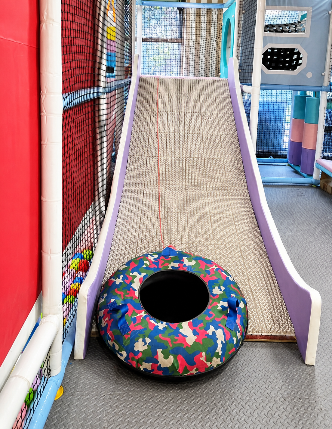 Indoor slide with soft padded landing tube